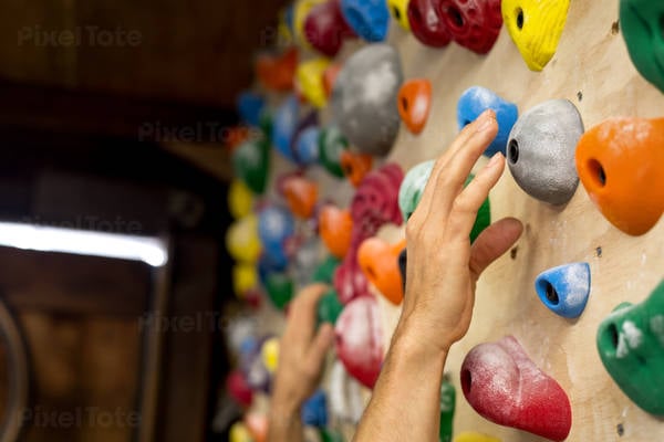 Man's Hand Reaching for a Hold on a Practice Wall at Home