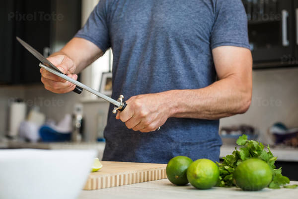  Man Sharpening a Knife in a Domestic Kitchen