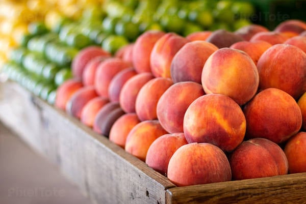 Ripe Peaches Stacked Neatly in a Corner Presentation at a Fruit Stand