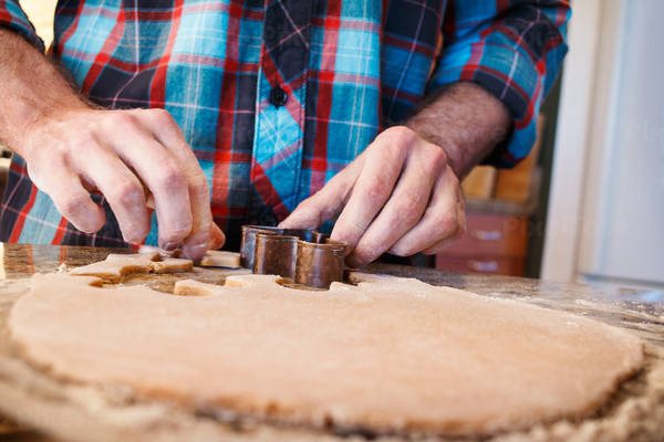 Man in a Flannel Shirt Baking Gingerbread Cookies at Home
