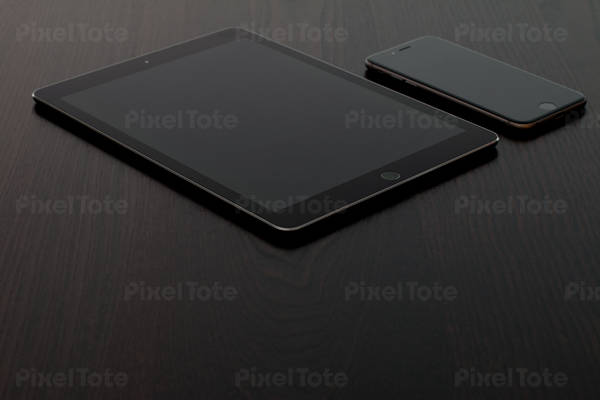 Detailed View of a Digital Tablet and Cell Phone on a Black Table