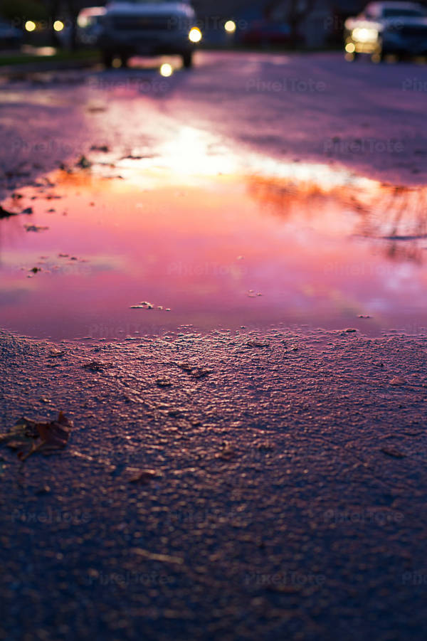 Dramatic Sunset Reflecting in the Puddle on a Street
