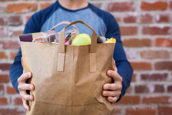 Close-Up of a Man Holding Paper Bag with Groceries