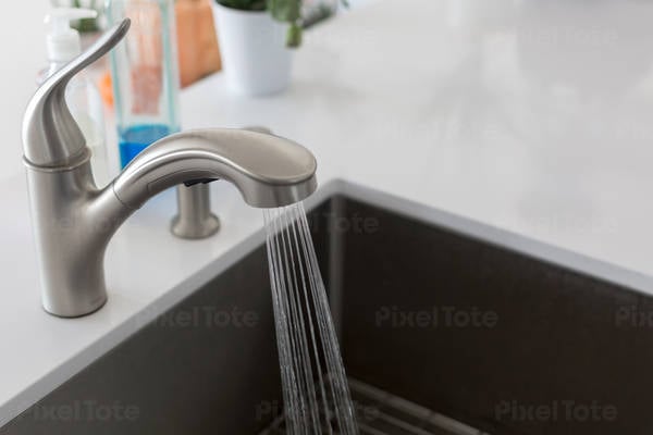 Close-Up View of a Kitchen Faucet with Running Water