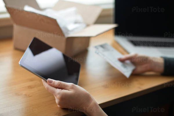 Woman Using a Tablet to Prepare Packages and Shipping Labels