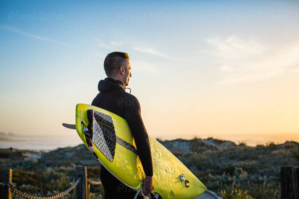 Surfer with a Yellow Surfboard Checking Waves Before Paddling Out