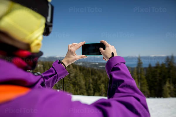 Female Skier Taking a Picture with a Camera Phone