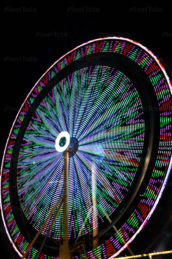 Blurred Motion of a Colorful Ferris Wheel at an Amusement Park at Night 