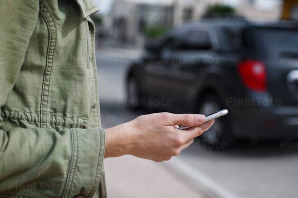 Woman Standing on a Street Holding a Cell Phone