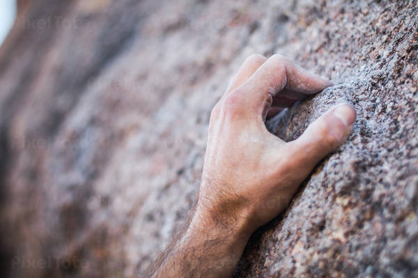 Close-Up of a Climber's Hand Crimping a Narrow Granite Hold