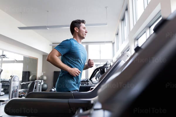 Man Running on a Treadmill in a Fitness Gym