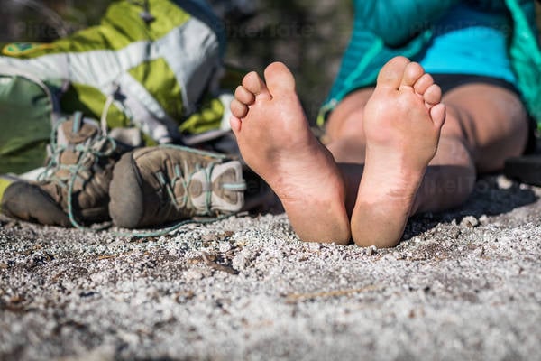 Bare Feet of a Woman Resting on the Ground After a Hike