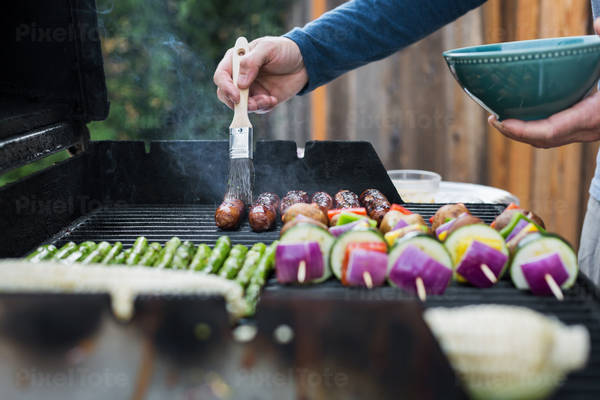 Man Braising Sausages on a Barbecue Grill in a Garden