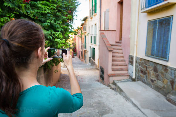 Woman Taking a Picture of a Street in a Town in Southern France
