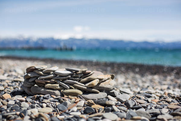Stack of Pebbles on a Rocky Beach by an Alpine Lake
