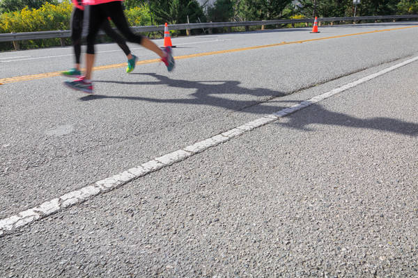 Low-Angle View of Two Marathon Runners on a Road
