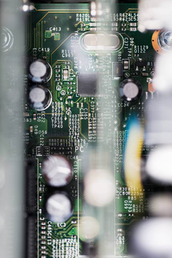 Close-Up View of a Green Circuit Board with Blurred Parts in Foreground