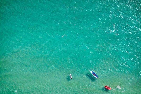 Aerial View of a Turquoise Sea Water with a Boat and a Jet Ski