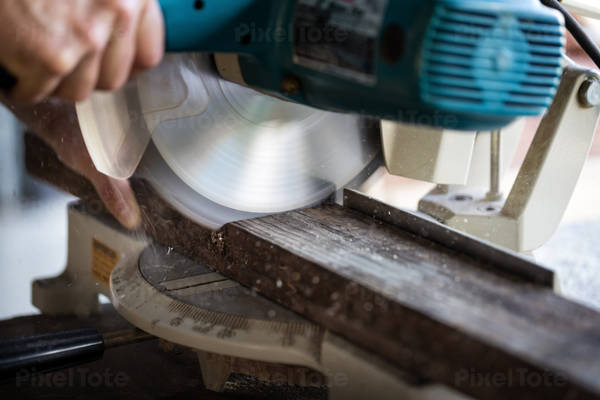 Close-Up of a Handyman Cutting a Wooden Board with a Miter Saw