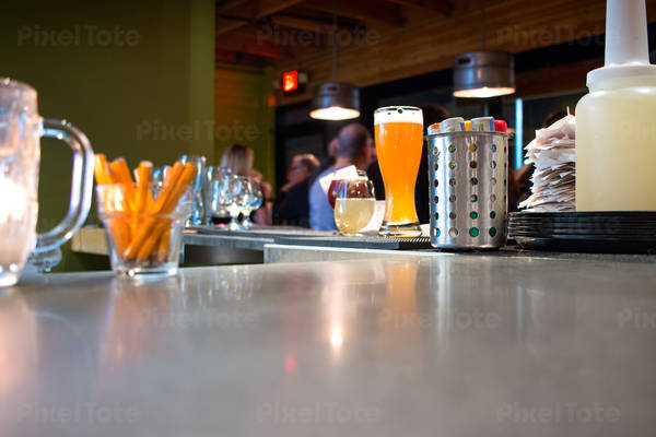 Low-Angle View of a Bar with a Glass of Beer and Utensils Showing