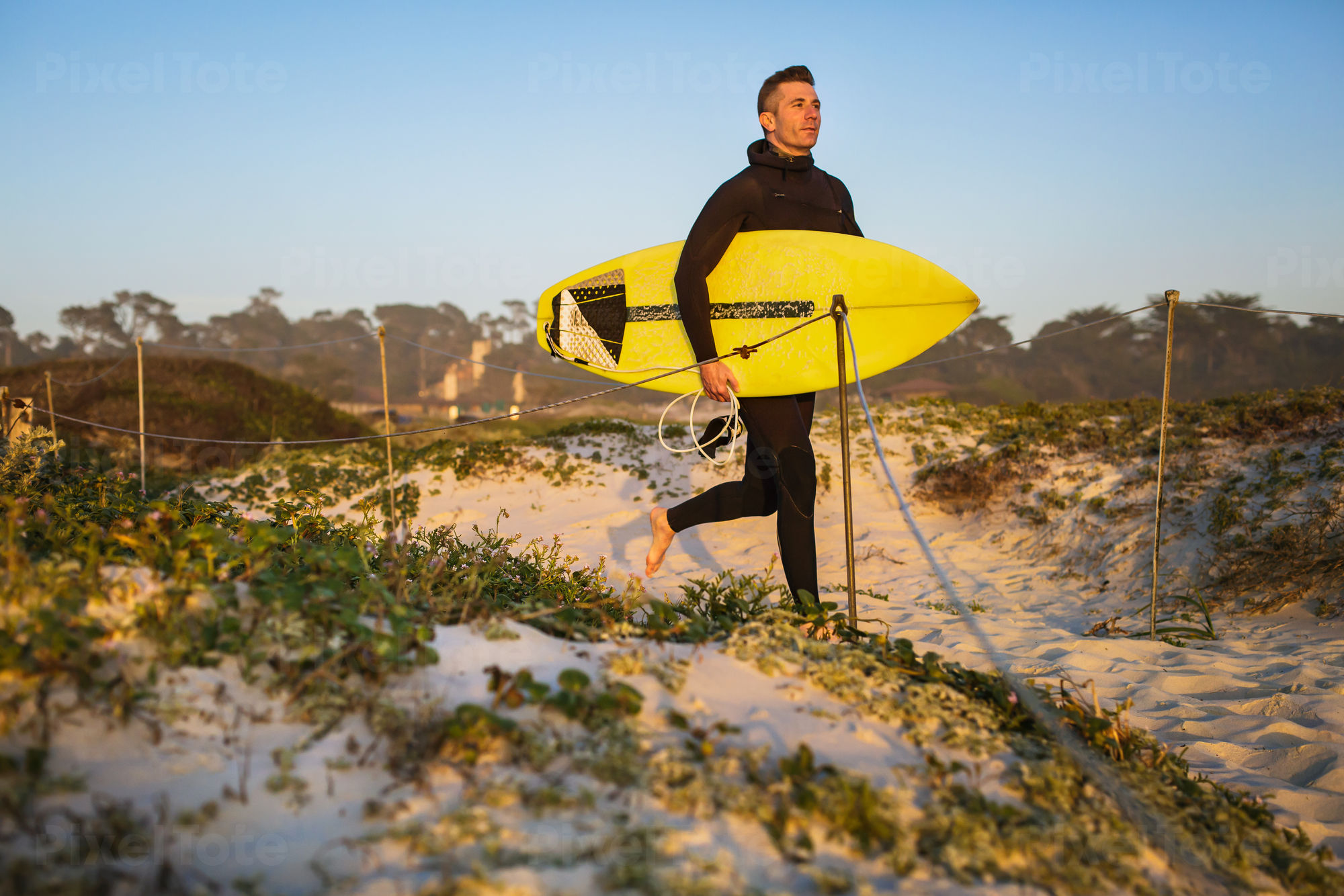 Male Surfer Running to a Beach Stock Photo - PixelTote