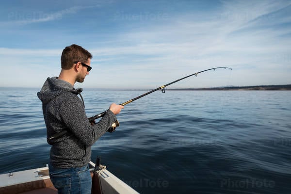 Man Fishing from a Boat in a Calm Ocean