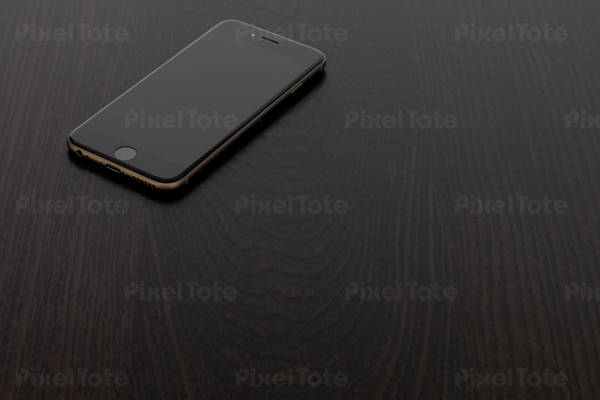 High-Angle View of a Black Cell Phone on a Wooden Table