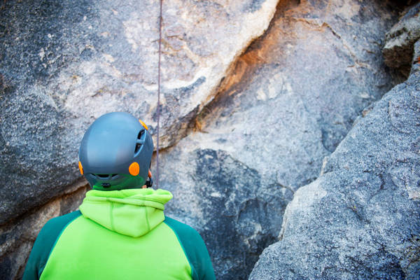 Climber Standing by a Rock Belaying His Climbing Friend