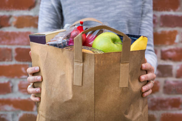 Close-Up of a Woman Holding Paper Bag with Groceries