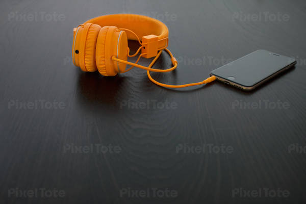 View of a Cell Phone and Headphones on a Black Table