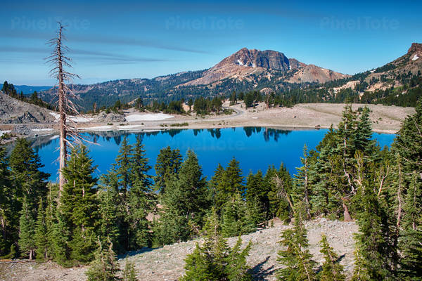 Scenic View of a Blue Mountain Lake with Trees and Patches of Snow