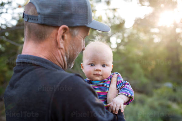 Dad Holding His Little Daughter in Nature