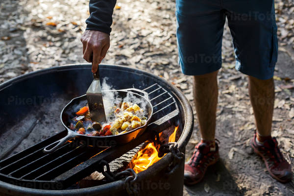 Man Cooking Breakfast on a Skillet on an Outdoor Fire Pit