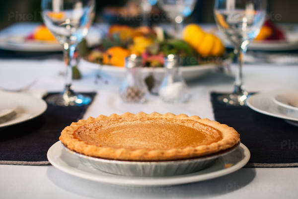 Low-Angle View of a Thanksgiving Table with a Pumpkin Pie in the Foreground
