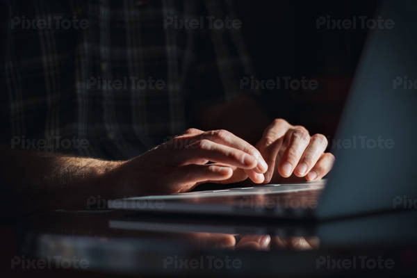 Man's Hands Typing on a Computer Keyboard in a Side Window Light