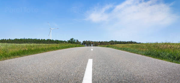 Panoramic View of a Landscape with a Road and a Wind Turbine