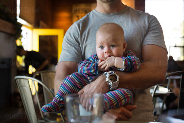 View of a Man Holding a Baby Girl in a Restaurant