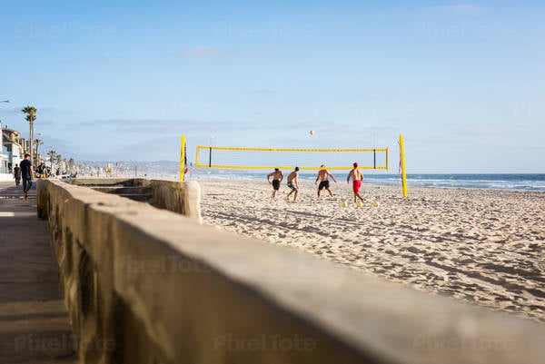 People Playing Volleyball on a Sandy Beach by the Ocean