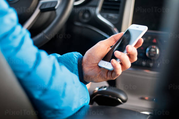 Outdoorsy Man Holding a Cell Phone in a Car