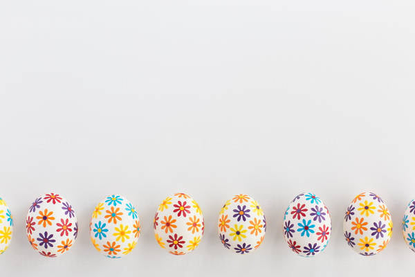 Easter Eggs Decorated with Flower Petal Stickers Arranged on a White Background