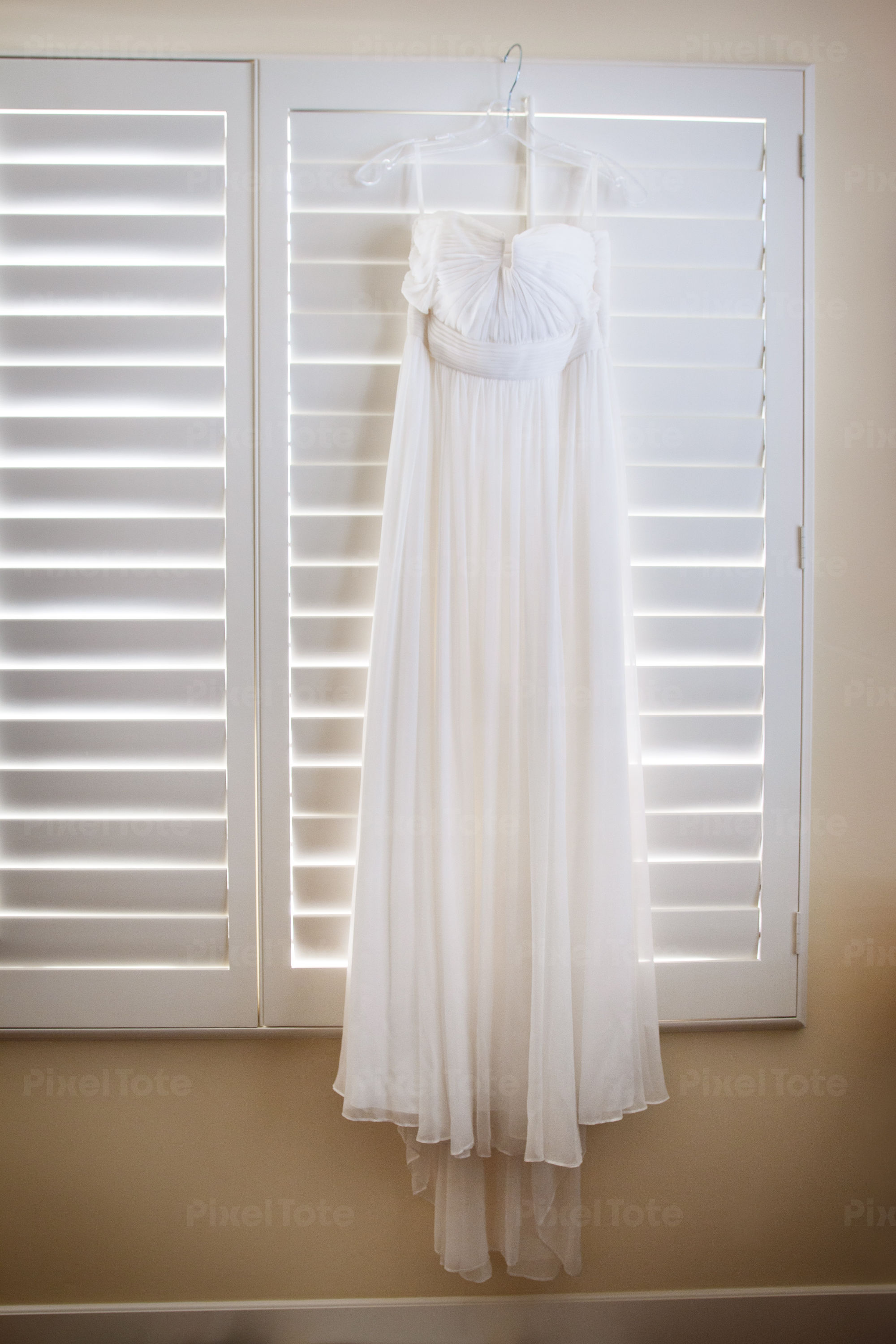 A Wedding Dress Hanging on White Stock Photo - PixelTote