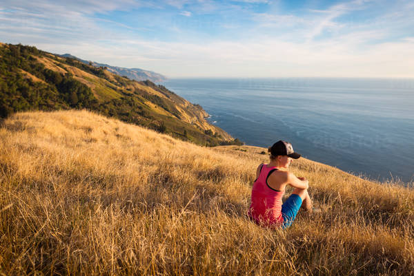 A Sitting Woman Enjoying View of a Coastline