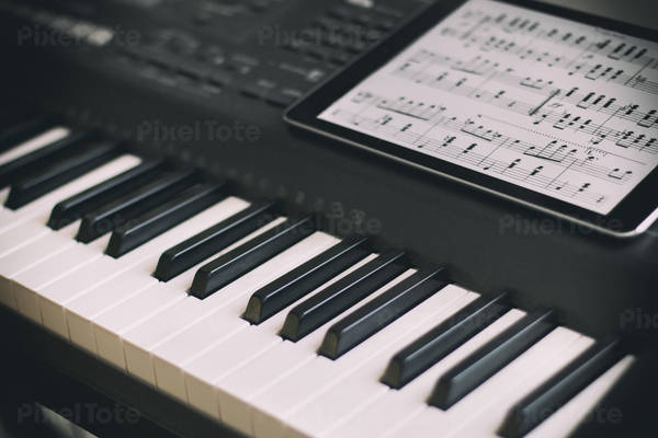 Keyboard Piano with a Digital Tablet with a Musical Score