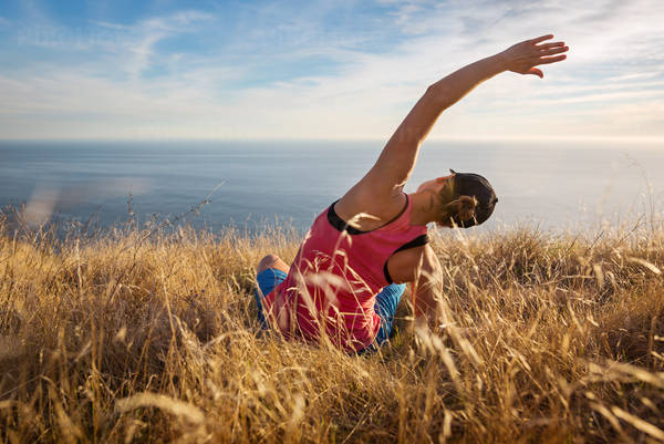 Woman Practicing Yoga and Enjoying an Ocean View