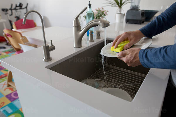 Hands of a Man Washing Dishes in a Sink in a Modern Kitchen
