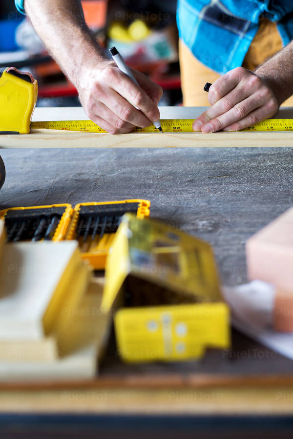 Handyman Using a Measuring Tape for His Woodworking Project in a Workshop
