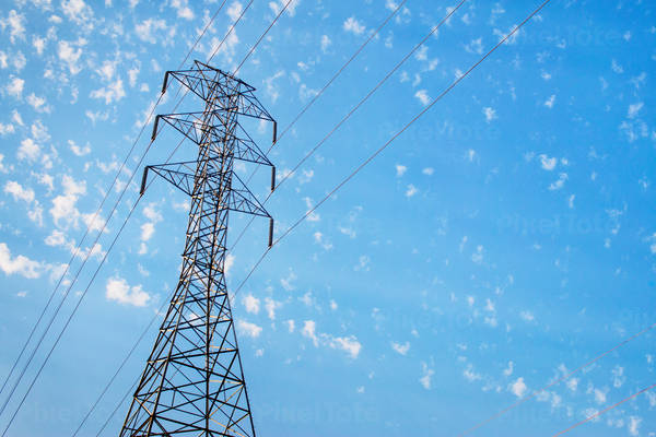 View of a Transmission Tower with Power Lines Against Blue Sky