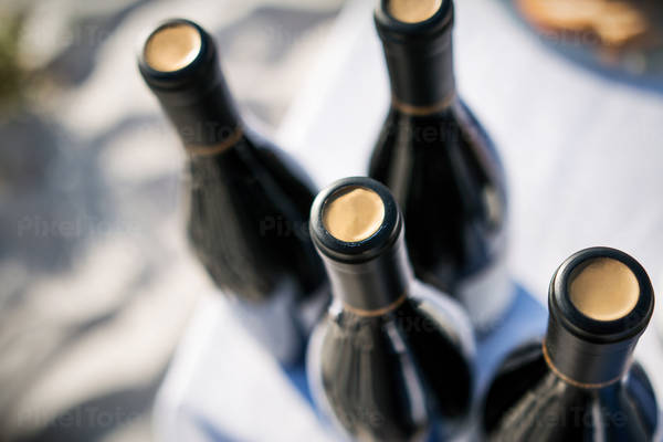 High-Angle View of Wine Bottles Placed on a Table with a White Tablecloth