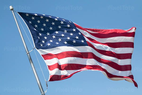 American Flag Flying in the Wind Against the Blue Sky