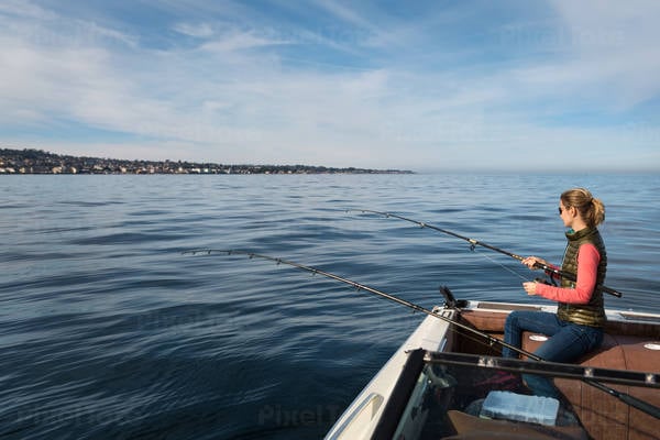 Young Woman Ocean Fishing from a Boat in a Bay